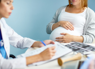 femme médecin qui écrit au premier plan, une femme enceinte est à l'arrière plan